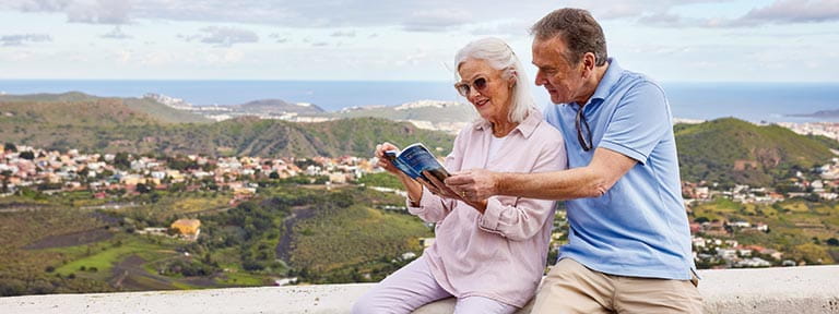 A couple looking at a guidebook in Las Palmas Caldera de Bandama in Gran Canaria, Canary Islands